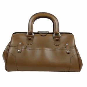 May include: A brown leather doctor's bag with a silver clasp and metal accents.