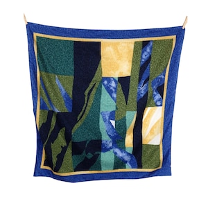 Könnte beinhalten: Ein quadratischer Schal in Blau und Grün mit gelbem Rand. Der Schal hat ein geometrisches Muster mit abstrakten Formen und Linien.