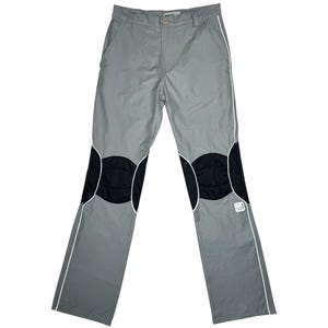 Peut inclure: Pantalon gris avec des empiècements noirs aux genoux et des bordures blanches. Le pantalon est doté d'une fermeture à bouton et à glissière, avec une petite étiquette près de l'ourlet droit. Style décontracté.