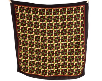 May include: A black silk scarf with a geometric pattern of red, green and white circles and triangles.