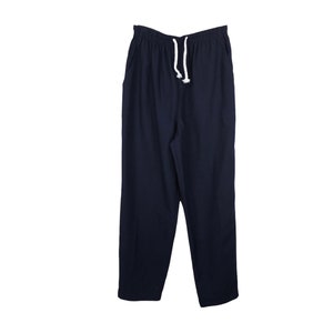 Puede incluir: Pantalones de chándal azul oscuro con cordón blanco.