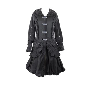 May include: A black coat with a ruffled hem and a high collar. The coat has silver buttons and white stitching.