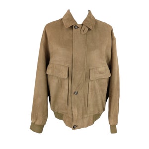 May include: A tan suede bomber jacket with a zipper closure and two large flap pockets. The jacket has a ribbed collar, cuffs, and hem.