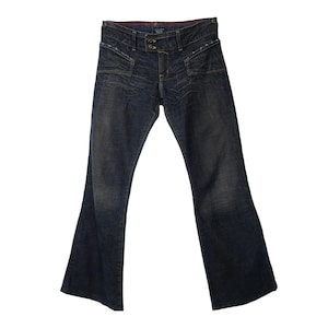 May include: A pair of dark blue denim jeans with a wide leg opening. The jeans have a button fly and belt loops.