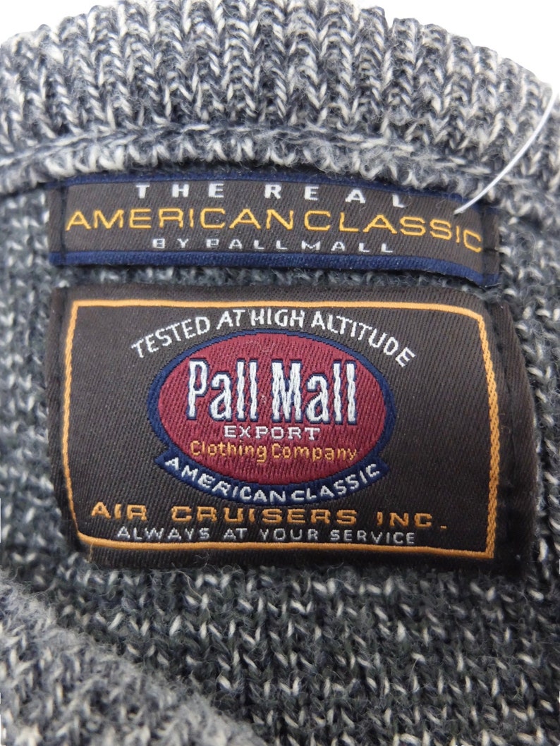 May include: A brown and black label with the text "Pall Mall Export Clothing Company" and "American Classic Air Cruisers Inc. Always at your service". The label also features a red circle with the text "Pall Mall" in white.