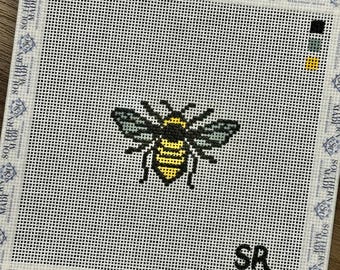 May include: Needlepoint canvas featuring a detailed bee design in yellow, black, and gray. The bee is centered on a white mesh background, with the initials "SR" in black. The canvas is bordered with a repeating "SOUTHERN MADE" pattern.