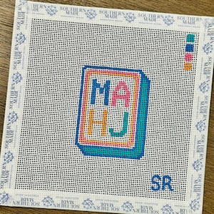 May include: Needlepoint canvas with the letters "MA HJ" in a colorful, blocky design. The letters are outlined in a bright pink, with a teal border. The canvas has a white background with the text "SOUTHERN MADE" around the edges.
