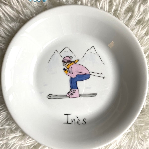 Petite skieuse dévalant les pentes à la montagne, assiette en porcelaine personnalisée avec prenom