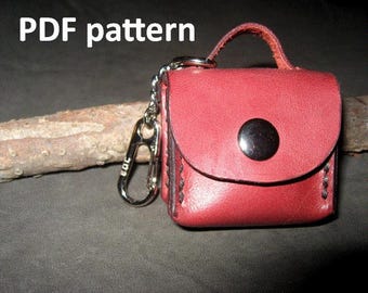 Könnte beinhalten: Ein roter Leder-Schlüsselanhänger mit einem kleinen Beutel in Form einer Handtasche und einem silbernen Verschluss. Der Schlüsselanhänger trägt den Text "PDF pattern" oben.