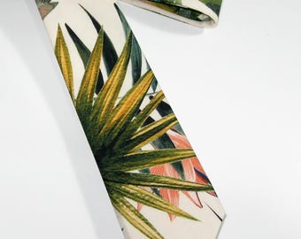 May include: A necktie featuring a cream-colored background with a vibrant botanical print of green palm leaves and subtle peach-toned accents. The text "NiceAccessories4U" is printed in a black script font at the bottom of the image.