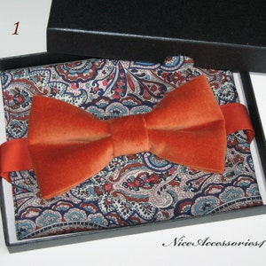 May include: A burnt orange velvet bow tie in a black box with a paisley patterned pocket square. The box has the text "Nice Accessories4U" on the bottom.