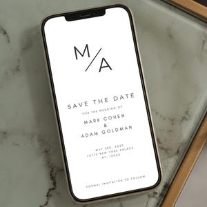 May include: A smartphone displays a minimalist wedding save-the-date announcement. The text includes the initials "M/A", "Save the Date", names, date, location, and "Formal Invitation to Follow". The design is in black and white.