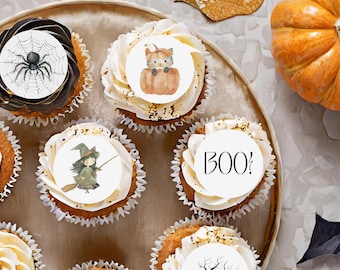 Peut inclure: Des cupcakes sur le thème d'Halloween avec diverses décorations. Certains cupcakes présentent des décorations comestibles avec une toile d'araignée, un chat dans une citrouille, une sorcière et le mot « BOO! ». Les cupcakes sont disposés sur un plateau décoratif.