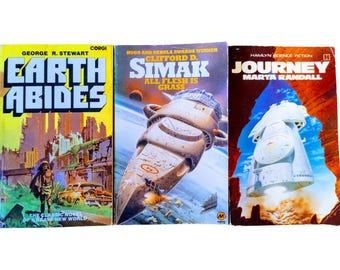 May include: Three paperback science fiction novels. The first is "Earth Abides" by George R. Stewart, the second is "All Flesh is Grass" by Clifford D. Simak, and the third is "Journey" by Marta Randall.