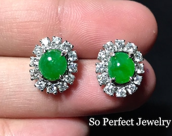 May include: A pair of jade and diamond earrings. Each earring features a round, green jade stone surrounded by a halo of sparkling diamonds.