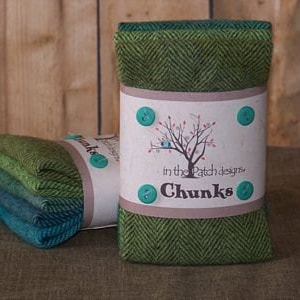May include: A set of four green and blue fabric squares with a herringbone pattern. The squares are wrapped in a brown paper band with a green tree and the text "In the Patch Designs, Chunks".