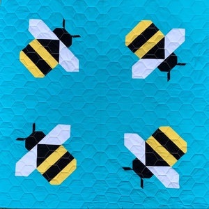 May include: A turquoise blue quilt with four black and yellow bee designs. The bees are made of fabric and have white wings.
