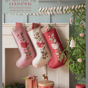 May include: Three Christmas stockings in red, pink, and white, each adorned with a bird and floral embroidery. The stockings are displayed above a fireplace, with gifts and decorations nearby. The text reads "Merry Little Christmas".
