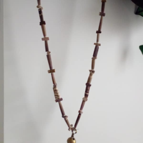 Collier guirlande faite avec des pics d'oursin et jolie clochette en cuivre qui fonctionne teintes marron et crème