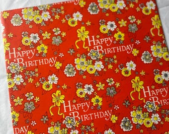May include: Red wrapping paper with a floral pattern and the text "Happy Birthday" repeated throughout.