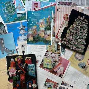 May include: A collection of vintage Christmas craft and sewing patterns. The patterns feature illustrations of angels, snowmen, and Christmas trees. The text on the patterns includes "Snow angels", "Angel choir", "Christmas project", "Your home for Christmas easily, inexpensively", "Trickets make gift packages unique", and "Patterns to help you copy Yuletide designs".