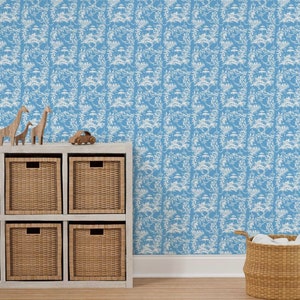 May include: A blue wallpaper with a white repeating pattern of stylized trees and flowers. The wallpaper is displayed in a room with a white shelf unit with six woven baskets and a toy car on top. A wicker basket with white fabric inside is on the floor.