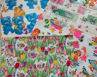 Könnte beinhalten: Sortiment an Babyparty-Geschenkpapier mit verschiedenen Mustern. Ein Blatt hat einen blauen Hintergrund mit Teddybären, die Instrumente spielen. Ein anderes Blatt hat einen rosa und weißen Hintergrund mit einem Baby in der Badewanne. Ein drittes Blatt hat einen grünen Hintergrund mit Tulpen und Hasen. Der Text auf einem Blatt lautet "Showers of happiness".