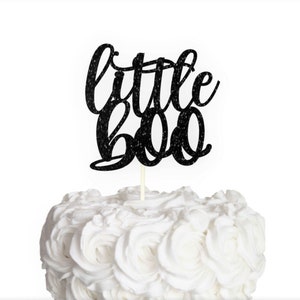 May include: Black glitter cake topper with the text "little boo" in a cursive font.