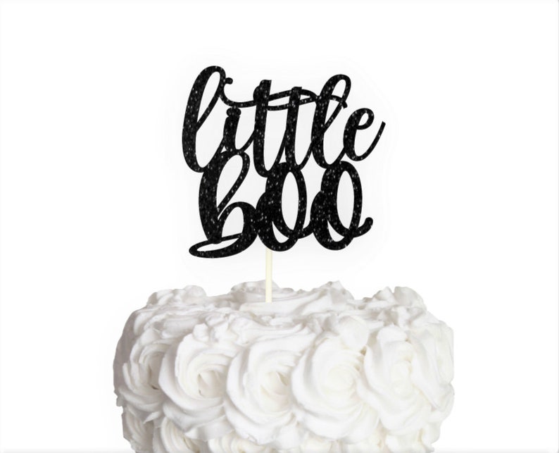 May include: Black glitter cake topper with the text "little boo" in a cursive font.