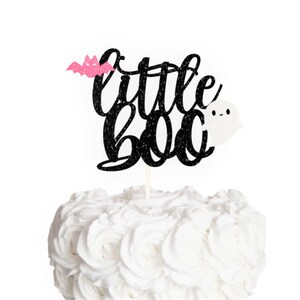 Puede incluir: Topper para pastel de purpurina negra con las palabras "little boo" y un murci&eacute;lago rosa y un fantasma blanco.