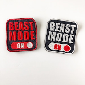 May include: Two square embroidered patches with rounded corners. The left patch has a black background with red text reading BEAST MODE and ON, featuring a white circle. The right patch has a black background with white text reading BEAST MODE and ON, with a red circle.