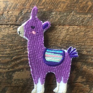 May include: Purple embroidered llama patch with a white saddle and a pink and blue striped design.