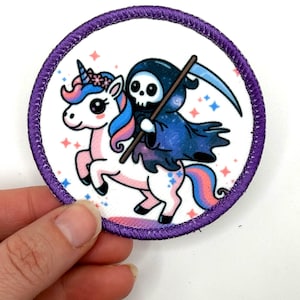 May include: Circular patch with a purple stitched border. The patch depicts a cartoon unicorn with a blue and pink mane and tail, ridden by a Grim Reaper figure in a blue cloak, holding a scythe.