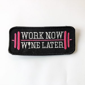 May include: Black embroidered patch with white text that reads "Work Now Wine Later" with a pink barbell graphic.