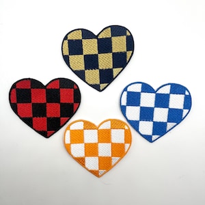 May include: Four heart-shaped patches with a checkered pattern. The patches are in red and black, blue and white, yellow and white, and navy blue and gold.