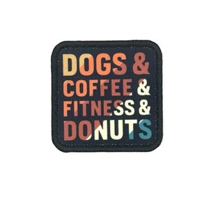 May include: A square black patch with rounded corners featuring the text DOGS & COFFEE & FITNESS & DONUTS in a multi-colored, layered font. The letters are colored in shades of yellow, orange, red, and blue, set against a dark background.