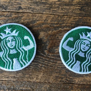 May include: Two green and white embroidered patches featuring a stylised woman with a crown and flexing her biceps. The patches are circular and have a white outline.