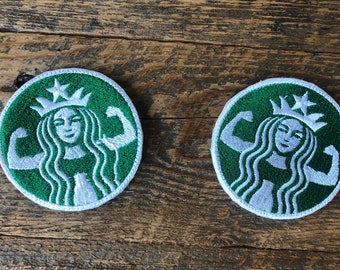 May include: Two green and white embroidered patches featuring a stylized woman with a crown and flexing her biceps. The patches are circular and have a white outline.