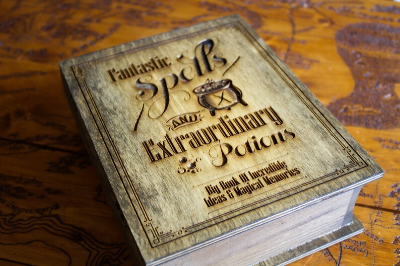 May include: A wooden box with a brown stain and a black engraved design. The box has the text "Fantastic Spells and Extraordinary Potions" and "Big Book of Incredible Ideas & Magical Memories".