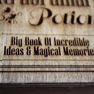 May include: A wooden box with the text "Big Book of Incredible Ideas & Magical Memories" engraved on the front. The box is made of wood with a natural finish.