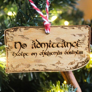 May include: A wooden Christmas bauble with the text "No admittance except on Christmas business" written in a decorative font.