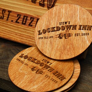 May include: Four wooden coasters with the text "STEW'S LOCKDOWN INN" and "OPEN TILL LATE" and the year "EST. 2020" engraved on them.