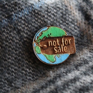 May include: A wooden pin shaped like the Earth with a tag that says "not for sale". The Earth is painted in shades of blue and green.
