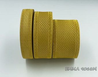 Puede incluir: Tres rollos de cinta de color dorado con un patrón texturizado. La cinta tiene aproximadamente 2,5 cm de ancho.