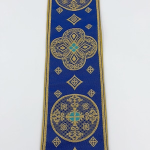 May include: A blue ribbon with gold filigree designs and turquoise accents. The ribbon features repeating circular and diamond patterns. The text "EMMA 253 No.11" is printed on the ribbon.