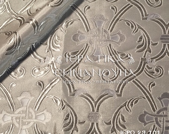 May include: A close-up of a silver fabric with an intricate floral pattern. The fabric has a raised texture and a subtle sheen. The text "IERATIKA - GMMANOYHX" is visible in the center of the image. The text "IGPO 29 101" is visible in the bottom right corner of the image.