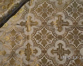 Pode incluir: Um close-up de um tecido dourado e branco com um padrão repetido de cruzes e desenhos florais. O tecido tem um brilho sutil e uma sensação luxuosa. O texto "IEPO 113 101" é visível no canto inferior direito da imagem.