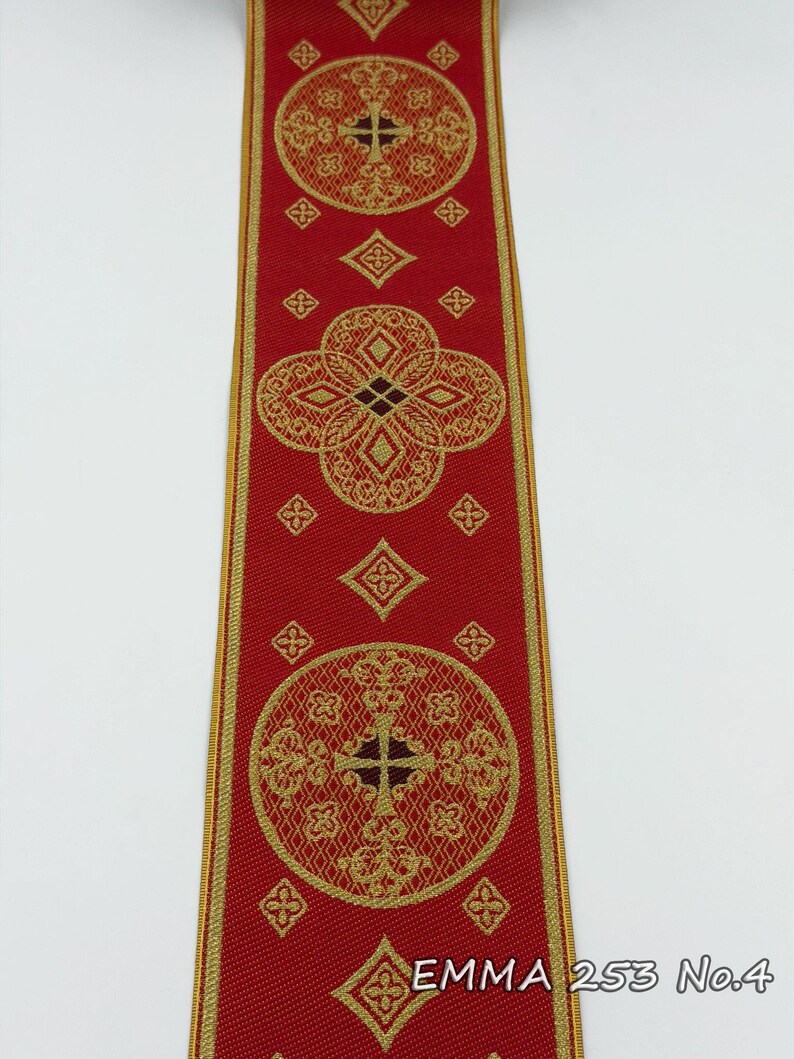 May include: Red ribbon with gold geometric patterns and the text "EMMA 253 No.4". The ribbon features repeating circular and diamond shapes with cross-like designs. The edges are trimmed with a gold border.