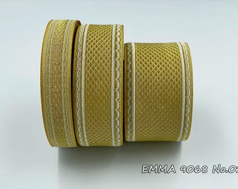 May include: Three rolls of gold ribbon with white trim. The ribbon has a diamond pattern and a scalloped edge. The ribbon is labeled "EMMA 9068 No.01".