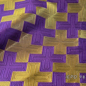 May include: Purple and gold fabric with a geometric pattern of interlocking crosses. The fabric has a textured, woven look. The text "IEPO 98 116" is printed in the lower right corner.